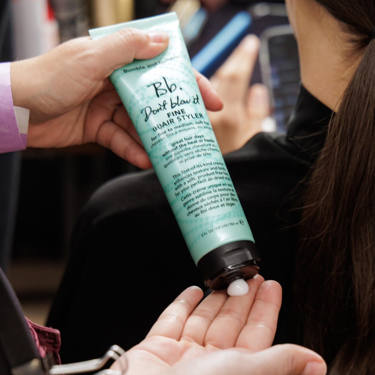 Bumble and bumble applying cream to damp hair for added volume