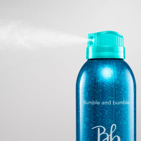 Bumble and bumble bottle held in hand illustrating 10 ounce size and portability
