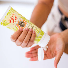 Burt's Bees lotion being dispensed into hand for easy application