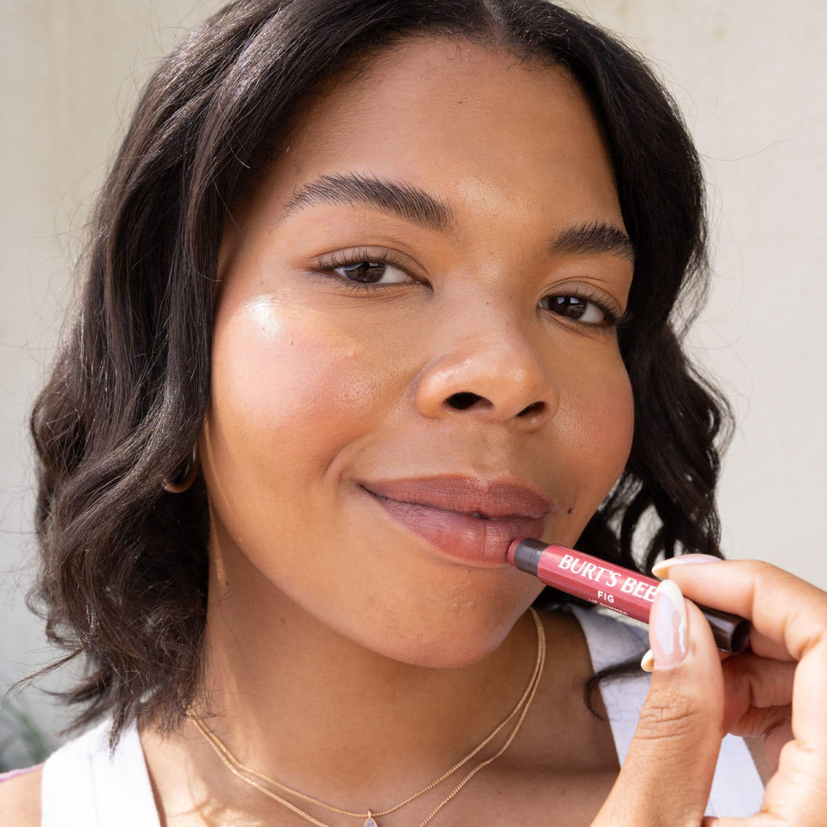 Burt's Bees applying shimmer lip tint to lips for instant glossy hydration