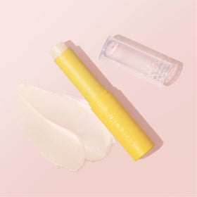 Burt's Bees Boosted Lip Balm next to a coin illustrating the small 0.16 oz travel size