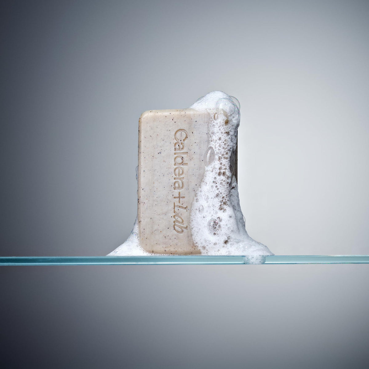 Caldera + Lab bar on shower ledge with water droplets, conveys spa-like shower experience
