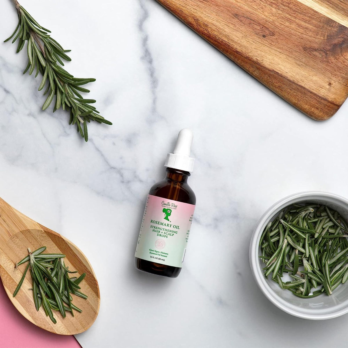 Camille Rose applying oil to scalp illustrating targeted nourishment benefit