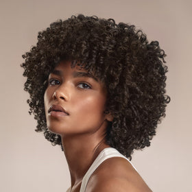Cantu applying leave-in to damp hair to show detangling and softness