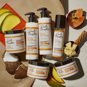 Carol's Daughter bottle beside coconut and shea illustrating nourishing ingredients