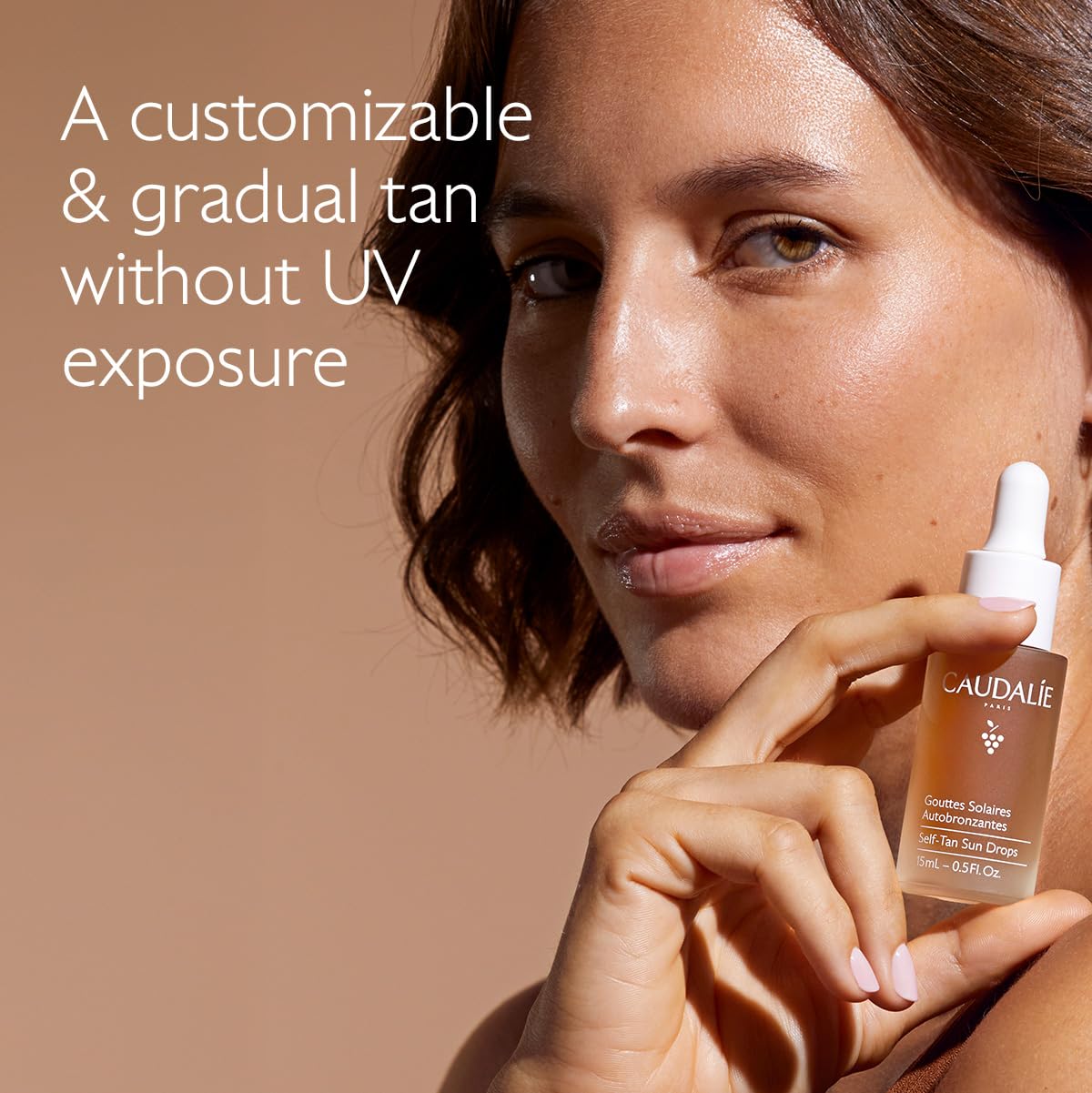 Caudalie close-up of dropper releasing tan drops, precise controlled application benefit