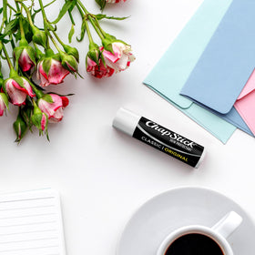 ChapStick Classic next to coin showing compact 0.15 oz size for portability
