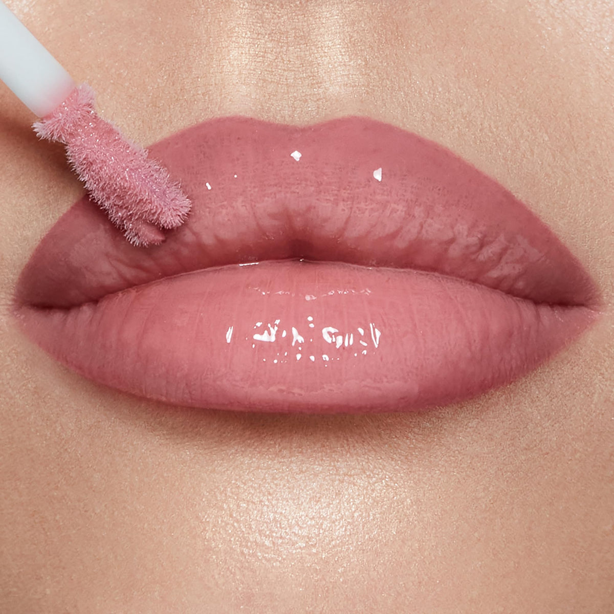 Charlotte Tilbury gloss held in hand to show supersize tube and scale