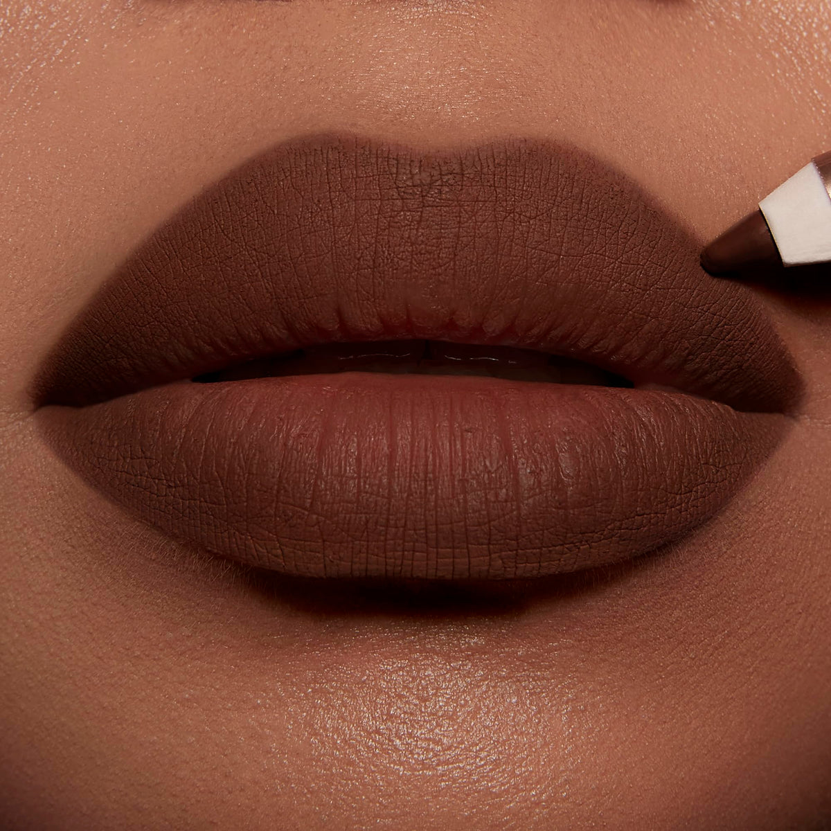 Charlotte Tilbury pencil in hand showing size and travel-friendly convenience