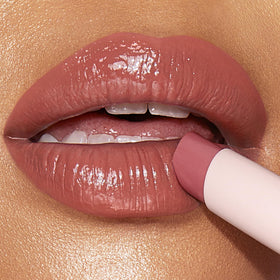 Charlotte Tilbury balm held in hand to show scale and travel-friendly size