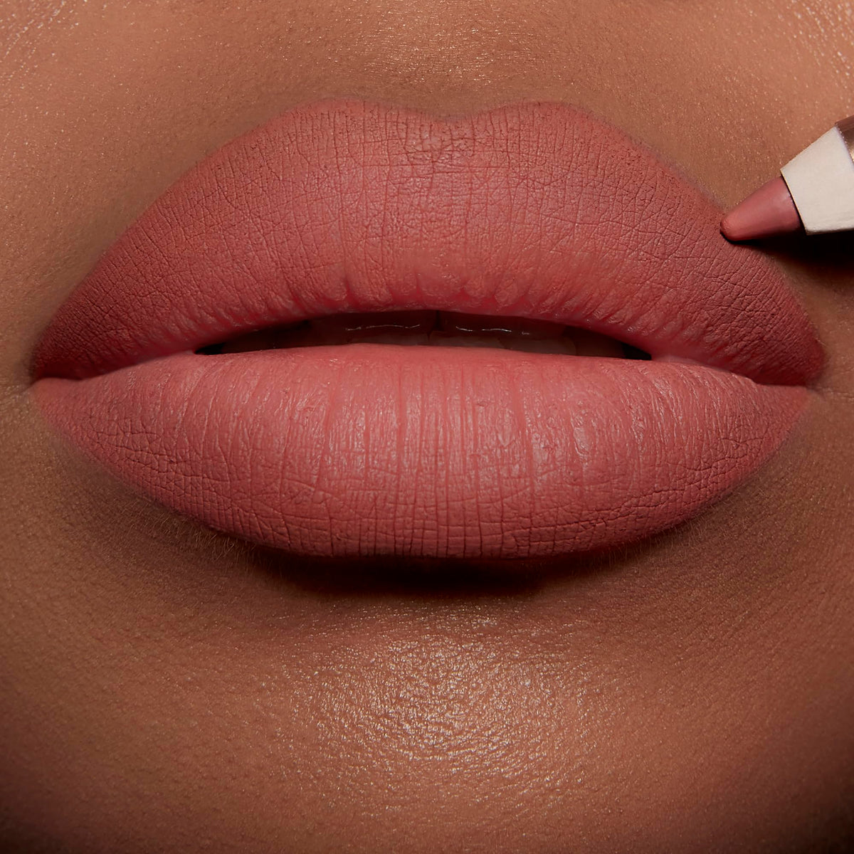 Charlotte Tilbury Lip Cheat pencil held in hand demonstrating easy application