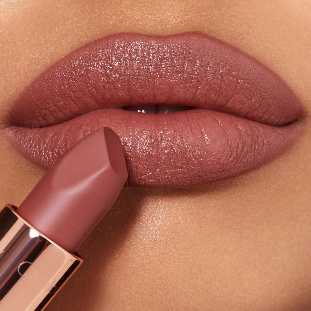 Charlotte Tilbury Supermodel shade applied to lips showing flattering mid-toned nude-rose finish