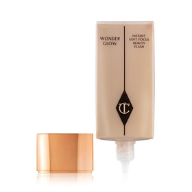 Charlotte Tilbury Wonderglow on vanity with mirror portraying daily routine and hydrated skin