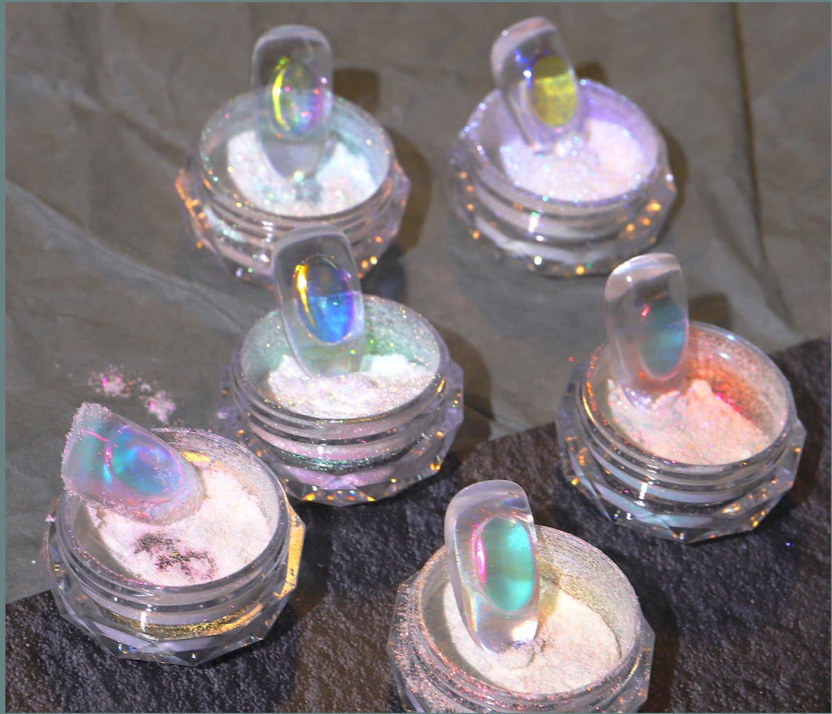 CHARMING MAY powder swatched on black gel showing intense neon holographic shift