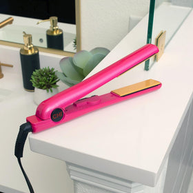 CHI flat iron held in hand to show 1 inch plate scale and comfortable styling control