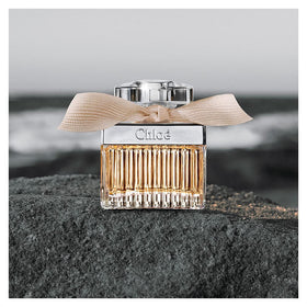 Chloe New By Chloe staged on vanity in romantic setting conveying evening-ready elegance