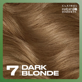 Hand holding Clairol Natural Instincts kit for size comparison showing three-pack value