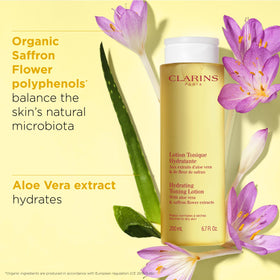 Clarins applying toner with cotton pad for gentle cleansing benefit