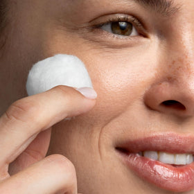 cliganic cotton ball held in hand demonstrating size and gentle use on skin