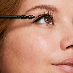 Clinique mascara next to measuring tape showing compact travel size