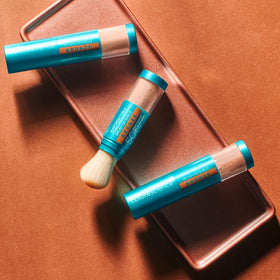 Colorescience brush-on shield bronze swatch on skin illustrating warm sun-kissed finish