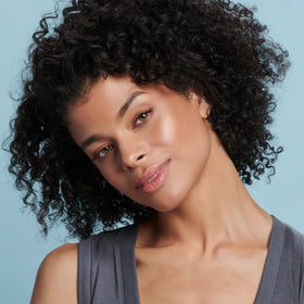 Model wearing Colorescience Face Shield Bronze outdoors showing natural radiance