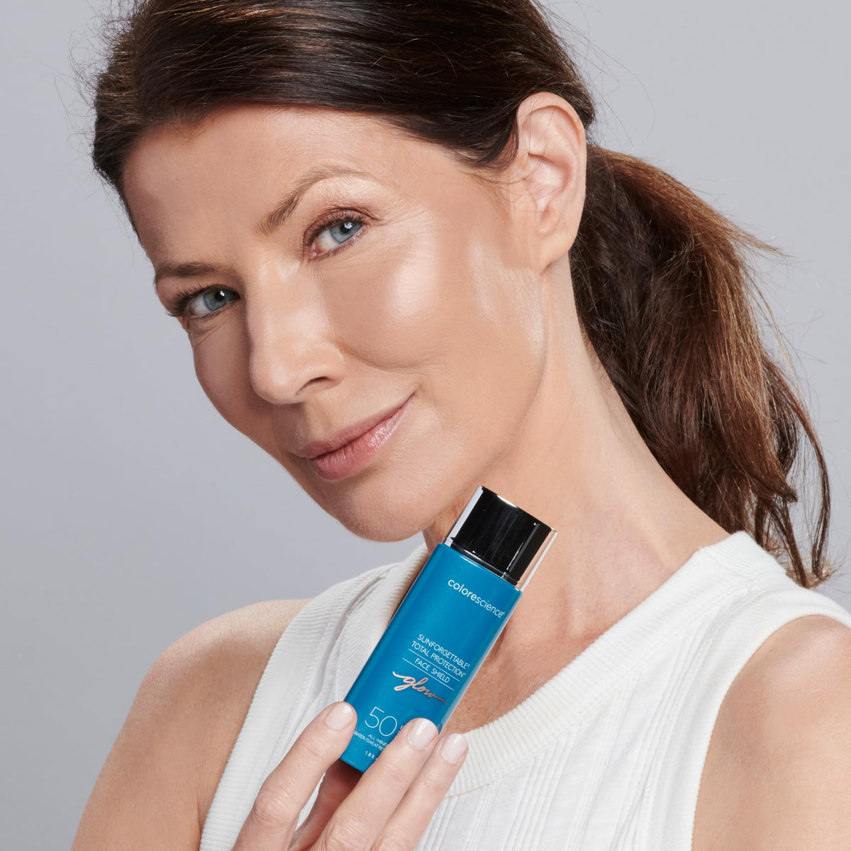 Colorescience Face Shield Glow applied on cheek demonstrating luminous, non-ashy finish benefit