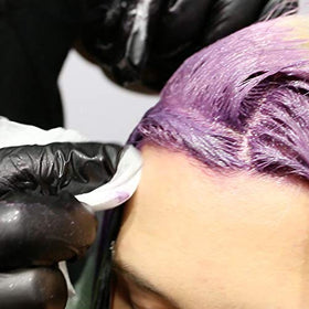 Stylist using Colortrak wipes to clean dye from fingers and tools quickly