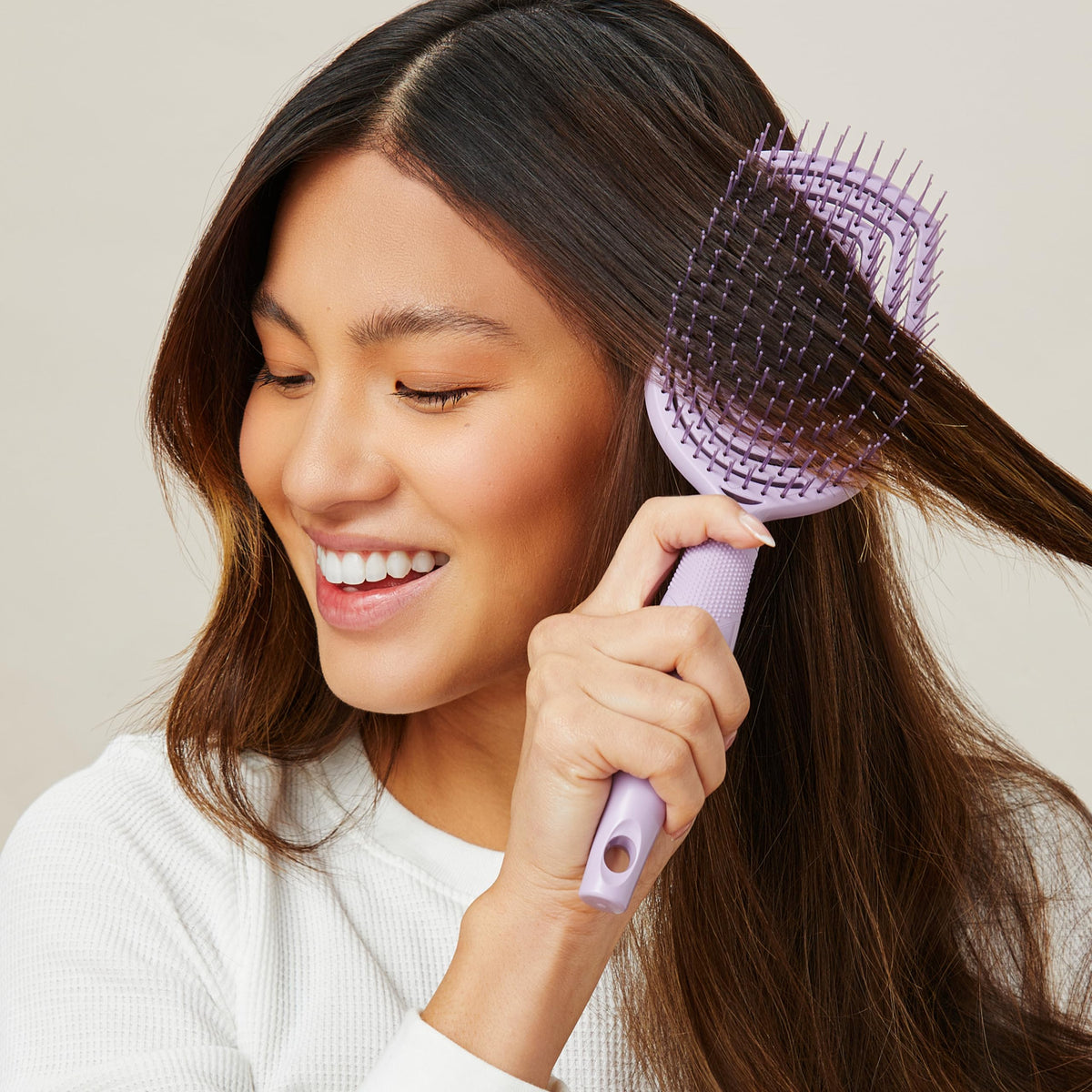 Conair brush held in hand showing paddle size for longer hair coverage