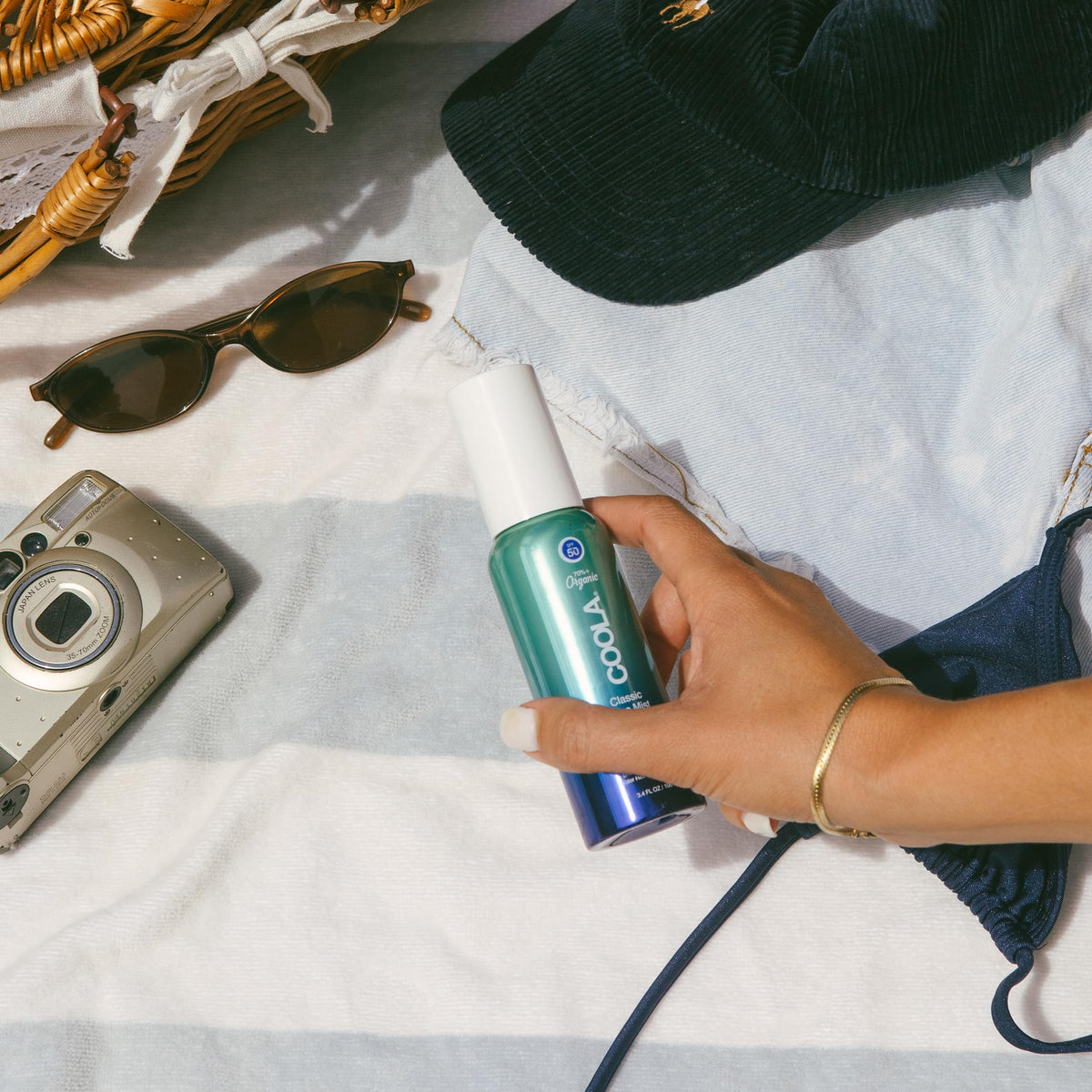 COOLA bottle in hand for size comparison and easy portability benefit