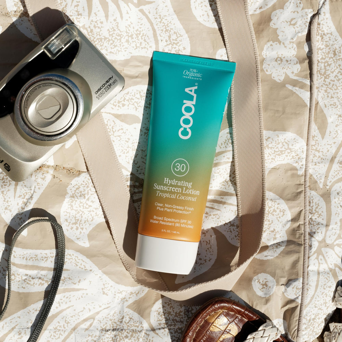 COOLA bottle on sandy beach demonstrating reef-safe outdoor use