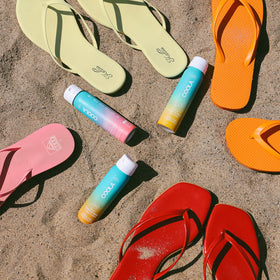 COOLA bottles in a beach bag lifestyle image highlighting outdoor protection