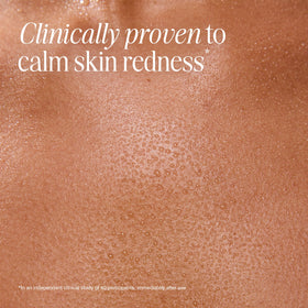 COOLA mist spraying on cheek to reduce redness and refresh