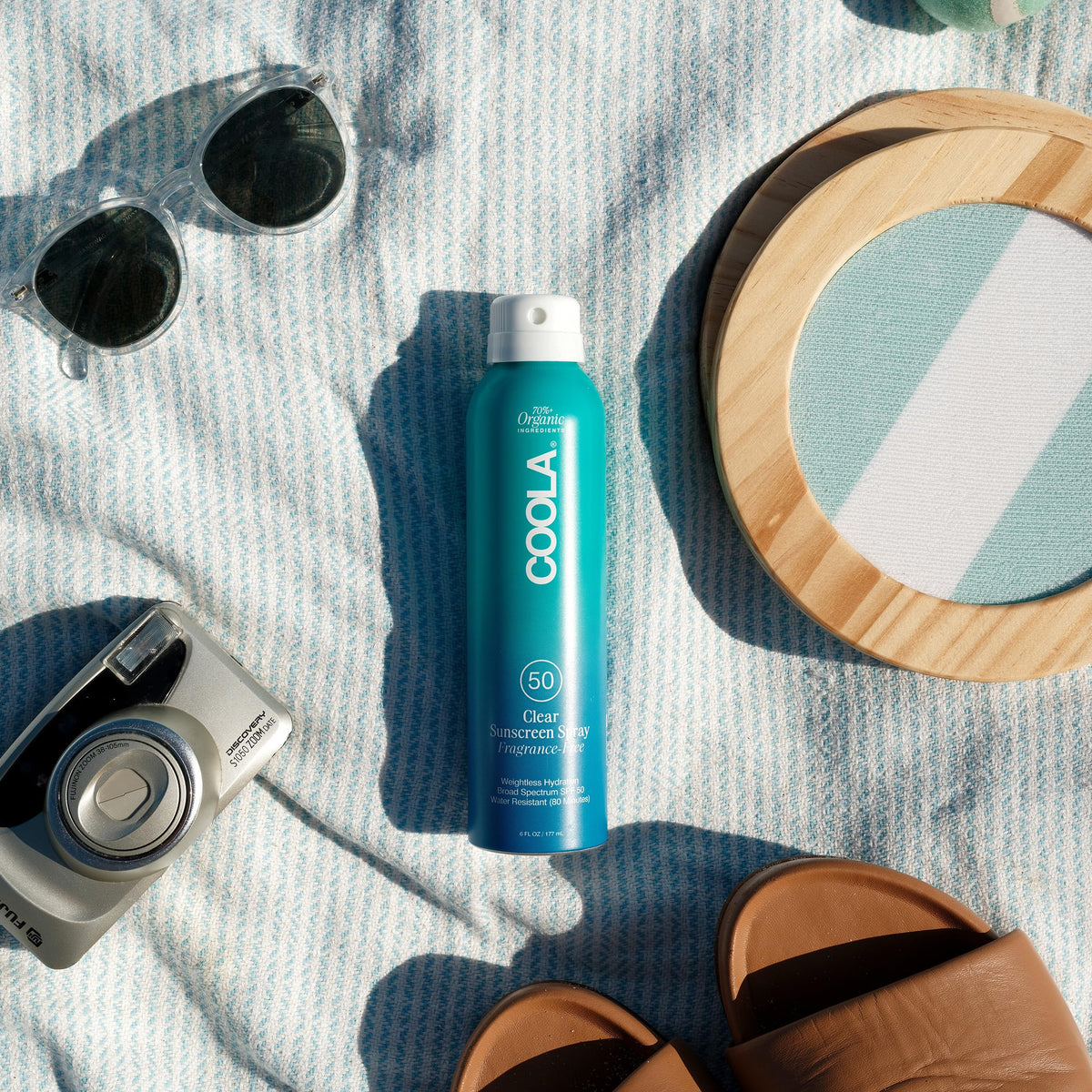 COOLA spray in hand being applied for quick, even coverage