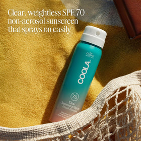 COOLA 2 fl oz bottle next to a coin for size scale, convenient travel protection