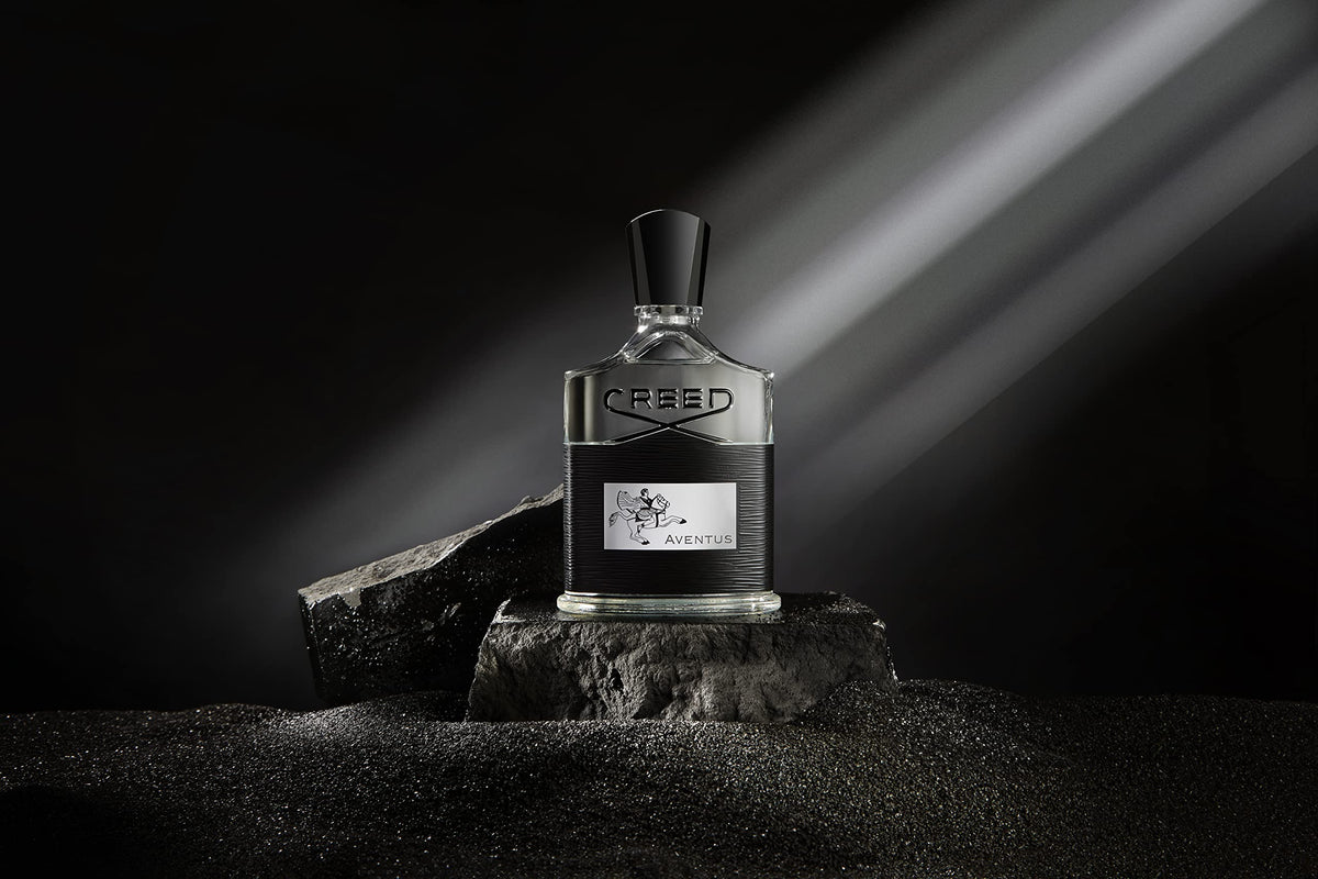 Creed Aventus bottle next to a hand for scale benefit: clear idea of 100 ml size