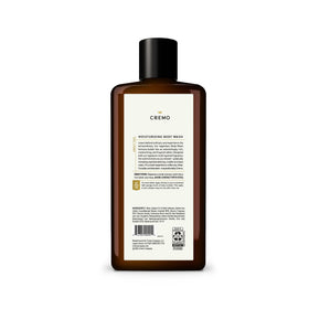 Cremo 16 fl oz bottle beside toiletries for scale and travel convenience
