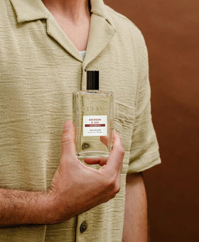 Cremo bottle beside oak wood highlighting bourbon and white oak character
