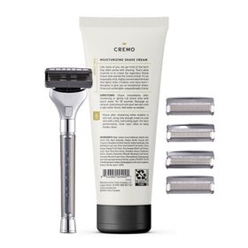 Cremo razor next to common toiletries showing compact size and travel readiness