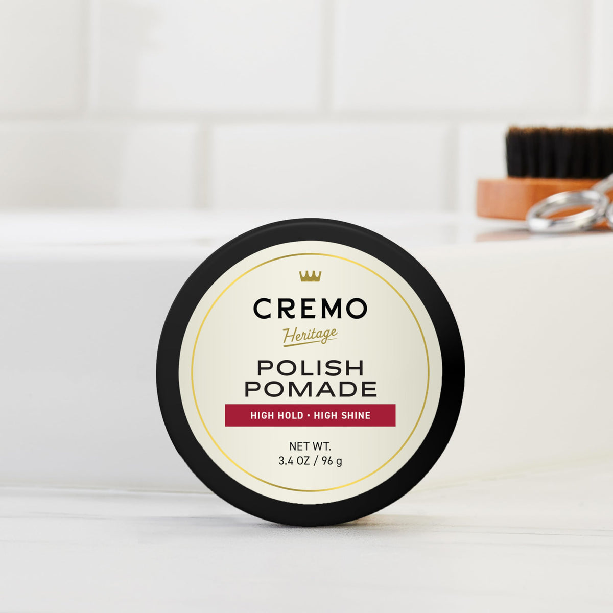 Cremo jar in hand to show 3.4 oz size and portability