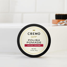 Cremo jar in hand to show 3.4 oz size and portability