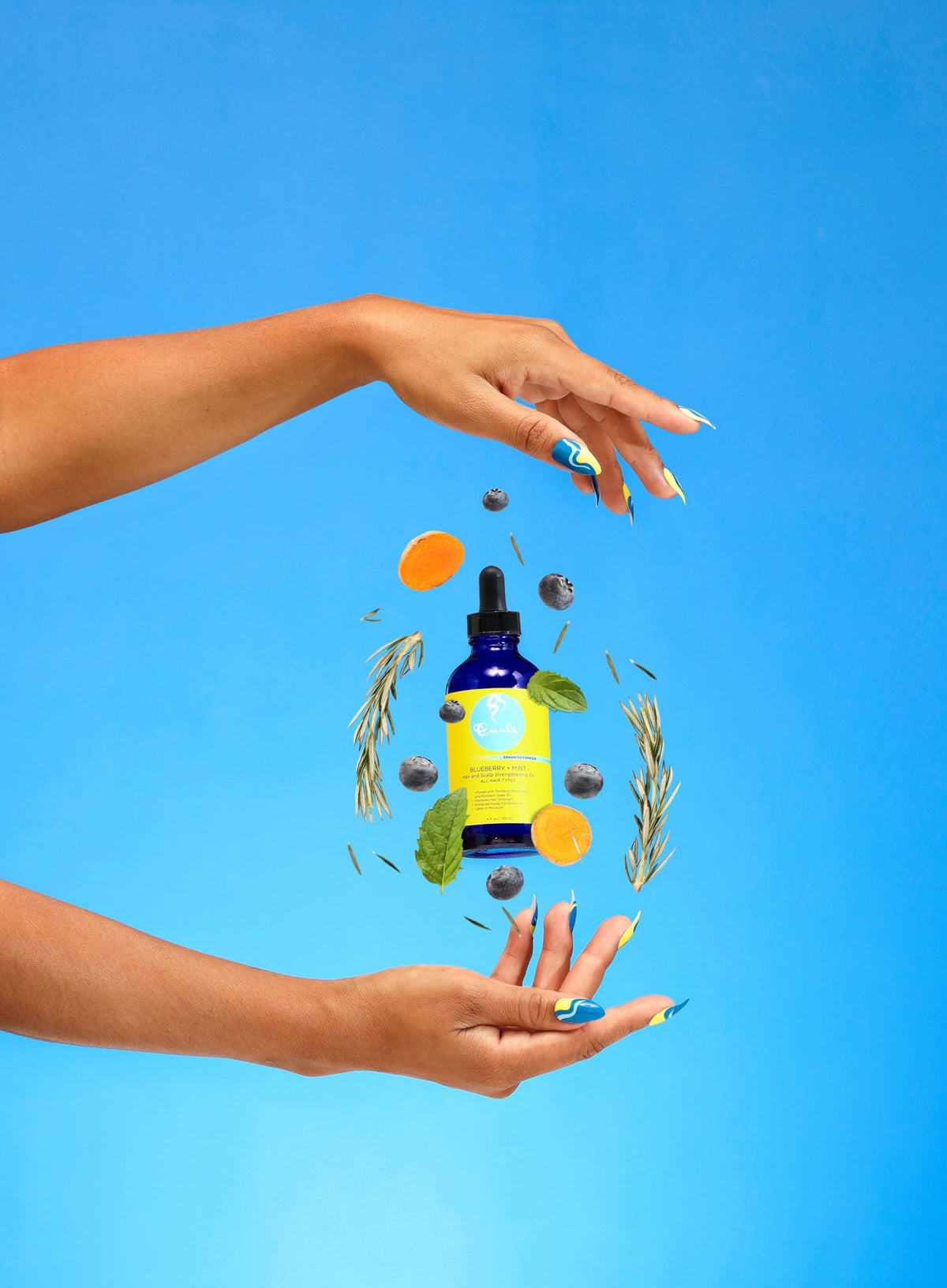 Curls applying oil to hair roots demonstrating scalp conditioning and moisture benefit