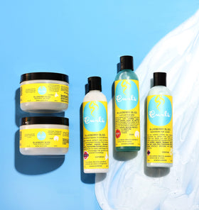 Curls Blueberry Bliss on bathroom shelf styled with towels showing everyday use and routine convenience