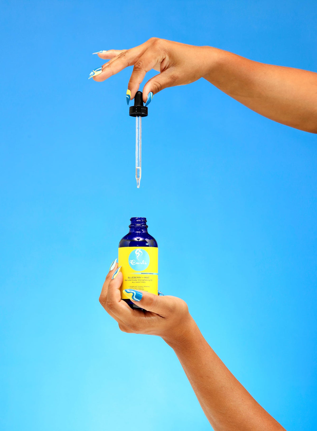 Curls bottle pouring oil to show pour action and controlled application benefit