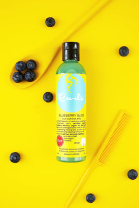 Curls Blueberry Bliss applied to wet hair in hand demonstrating easy spread and slip