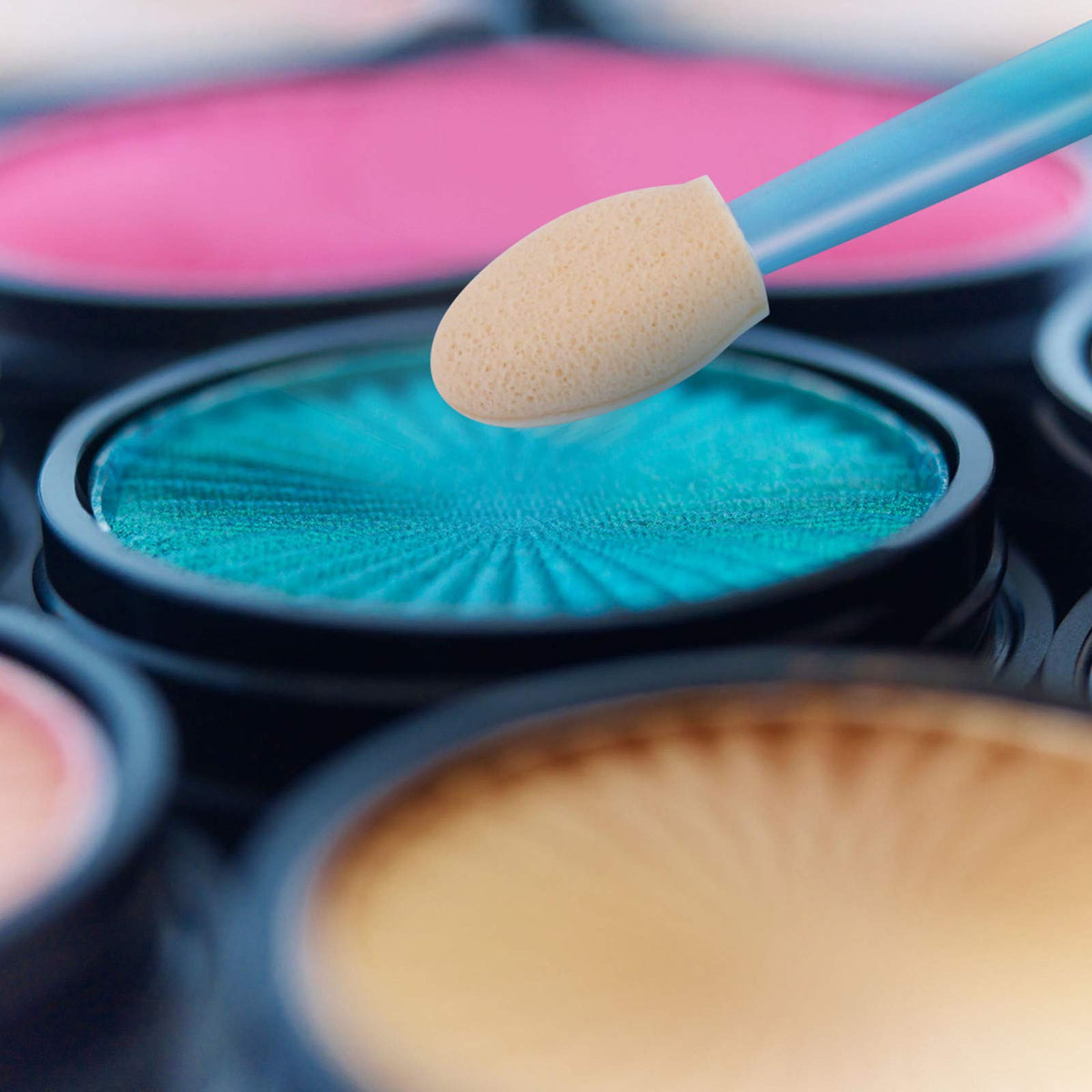 Cuttte applicator applying eyeshadow on eyelid for accurate crease definition