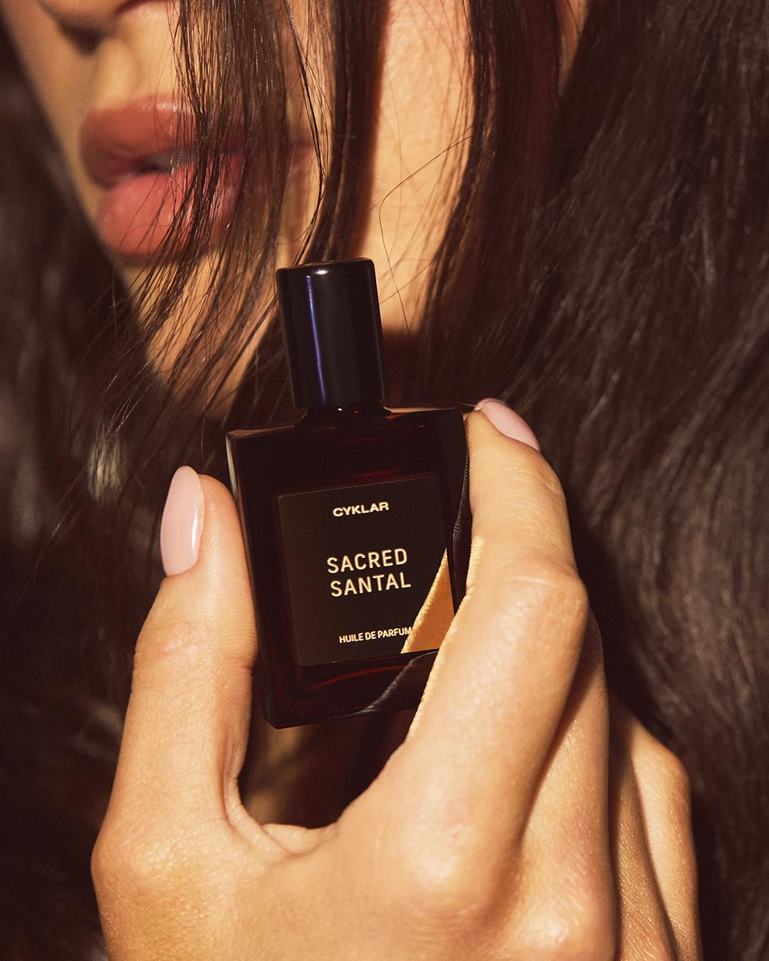 CYKLAR Sacred Santal ingredients visual with bergamot and amber accents