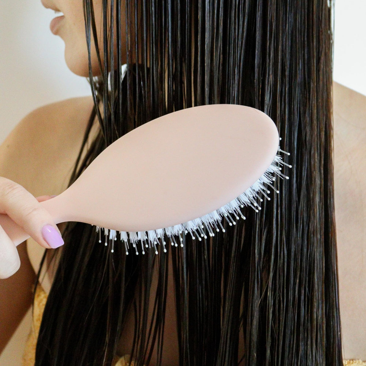 DAE brush held in hand to show scale and user-friendly grip for comfortable brushing