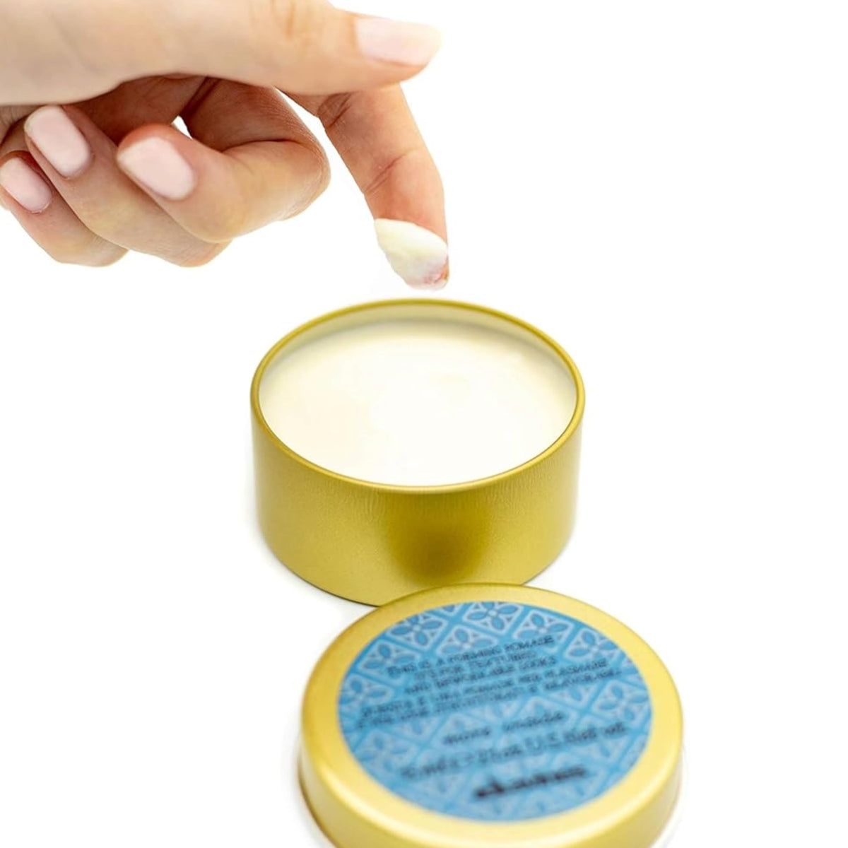 Davines hand applying a small amount of pomade demonstrating easy distribution