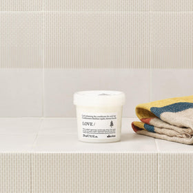 Davines conditioner applied to wet curls showing detangling action